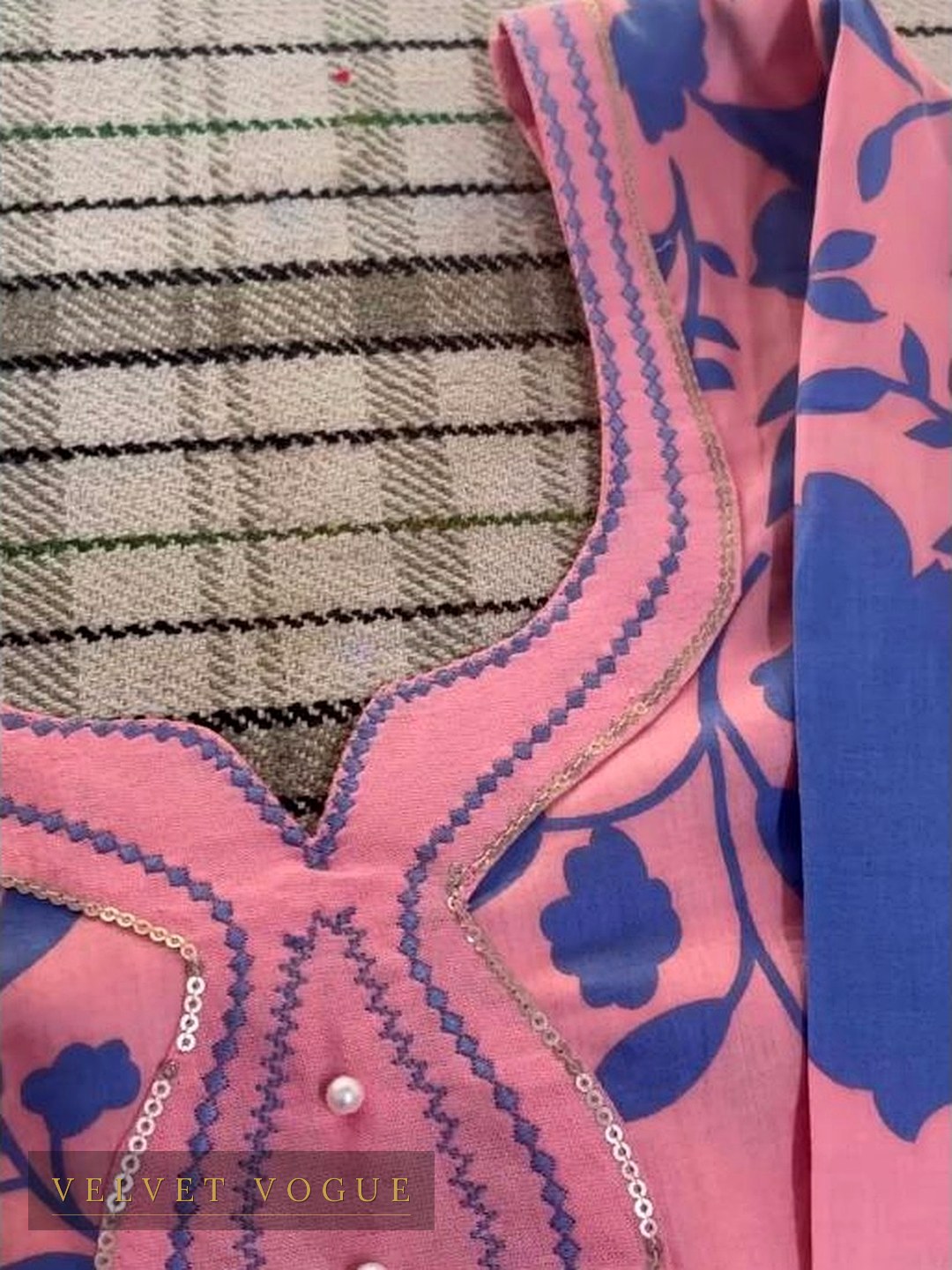 Zigzag stitching run along the curve of the neckline, sequin edging, one pearl closing the placket.