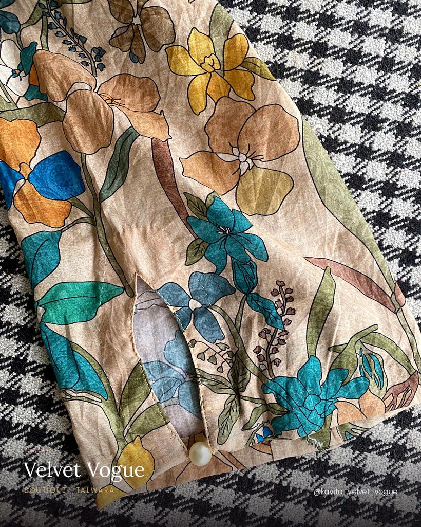 A pointed cuff on floral print, closed with a single pearl.