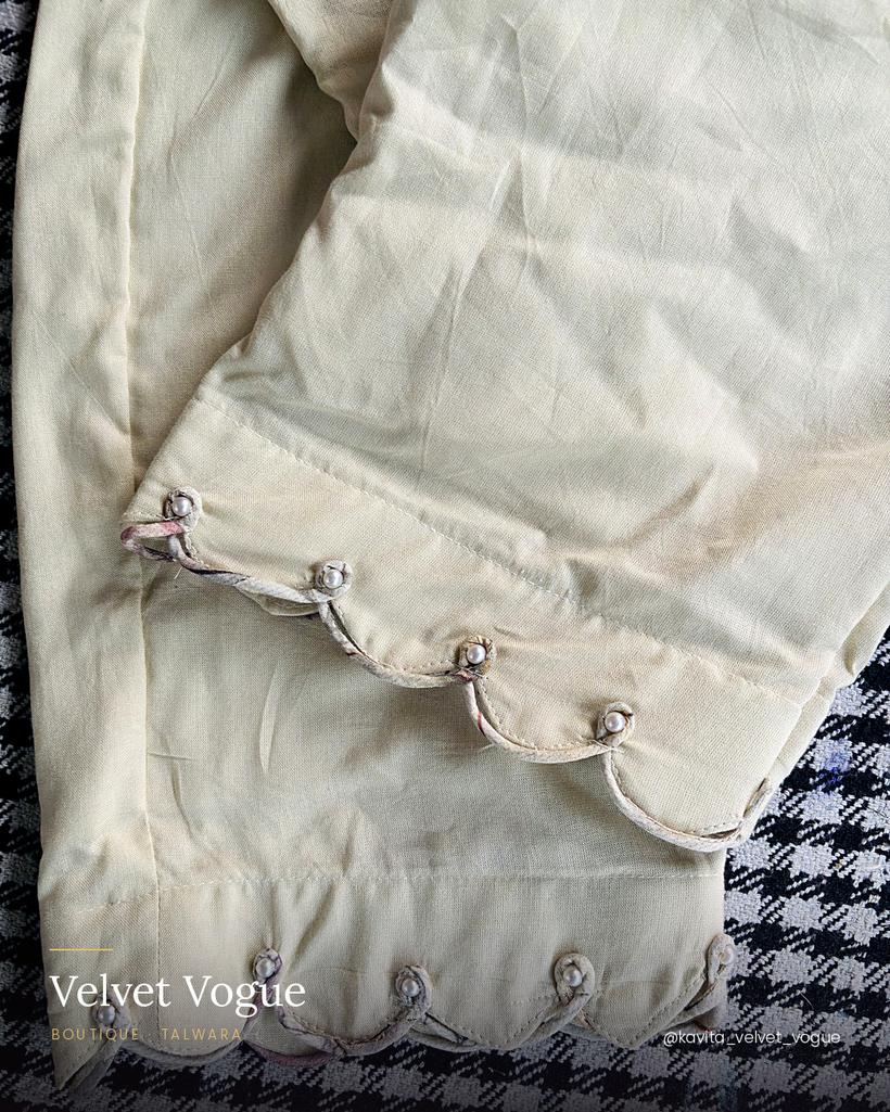 A scalloped hem finished with pearls — an hour of work on a single pair.